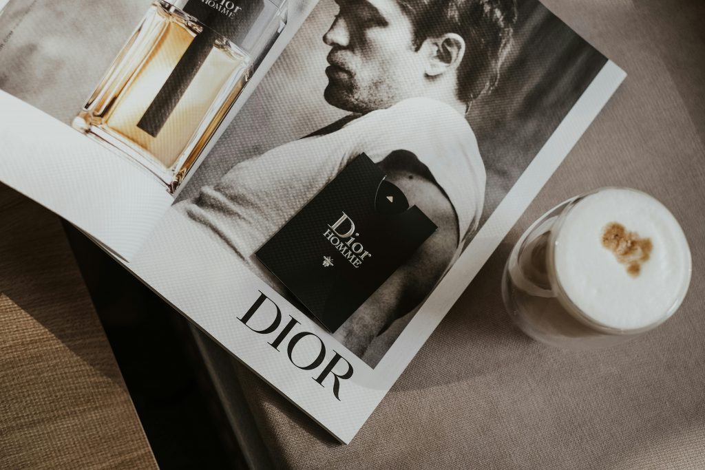 Elegant flat lay featuring a Dior magazine and a stylish coffee, suggesting luxury and sophistication.