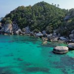 Aerial shot of the stunning tropical Shark Bay with turquoise waters and lush greenery in Koh Tao, Thailand.