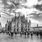 Black and white photo of Duomo di Milano with a crowd in the public square.